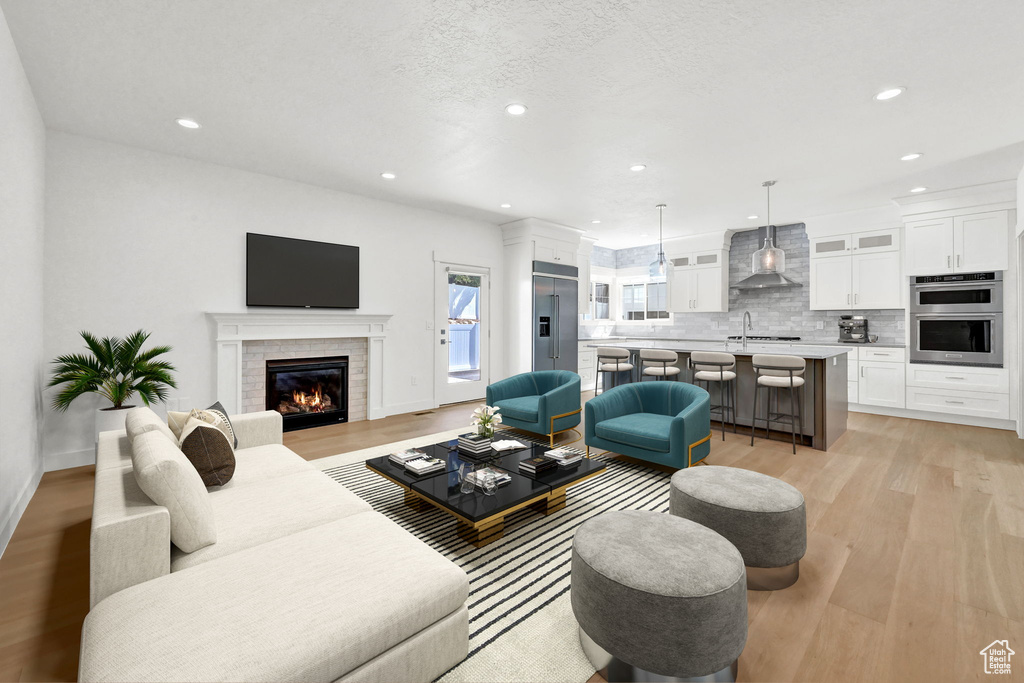 Living room with light hardwood / wood-style flooring, a textured ceiling, and sink