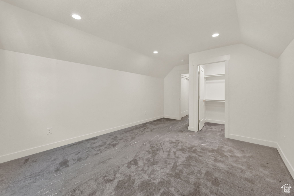 Additional living space with lofted ceiling and light carpet