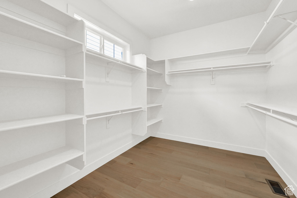 Spacious closet with hardwood / wood-style flooring