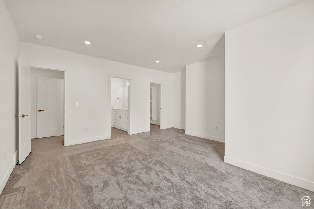 Unfurnished bedroom featuring light carpet and ensuite bath