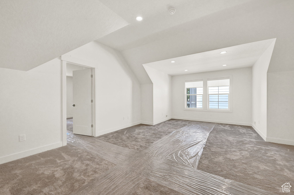 Bonus room featuring light carpet and vaulted ceiling