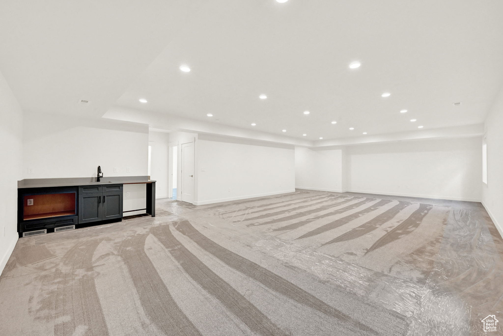 Interior space with light carpet and wet bar