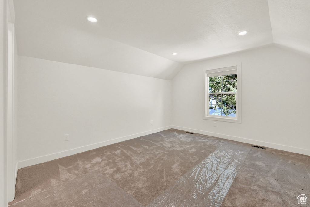 Bonus room with carpet floors and vaulted ceiling