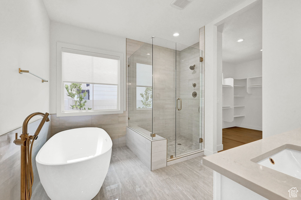 Bathroom featuring independent shower and bath, vanity, and hardwood / wood-style floors