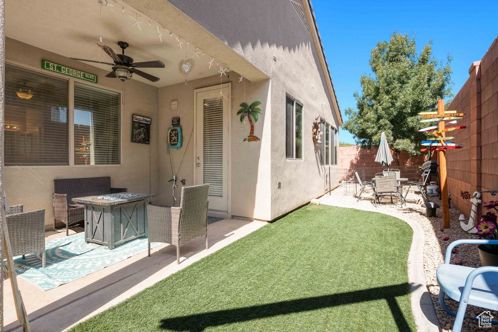 View of yard featuring ceiling fan, a patio area, and an outdoor fire pit