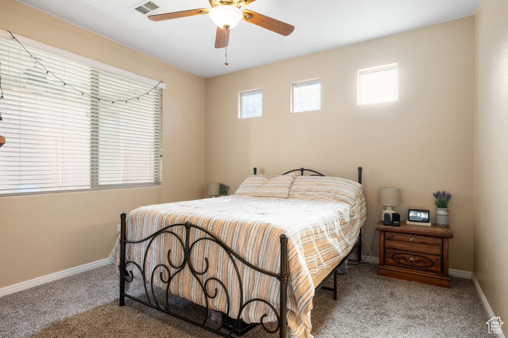 Bedroom with ceiling fan and light carpet