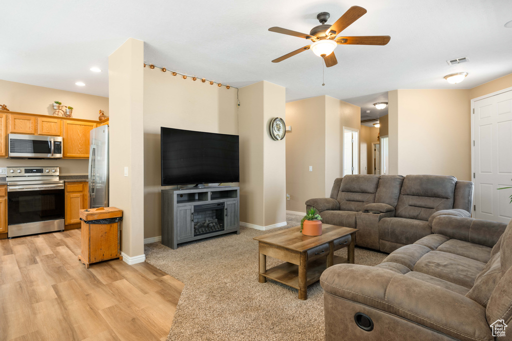 Living room featuring light hardwood / wood-style floors and ceiling fan