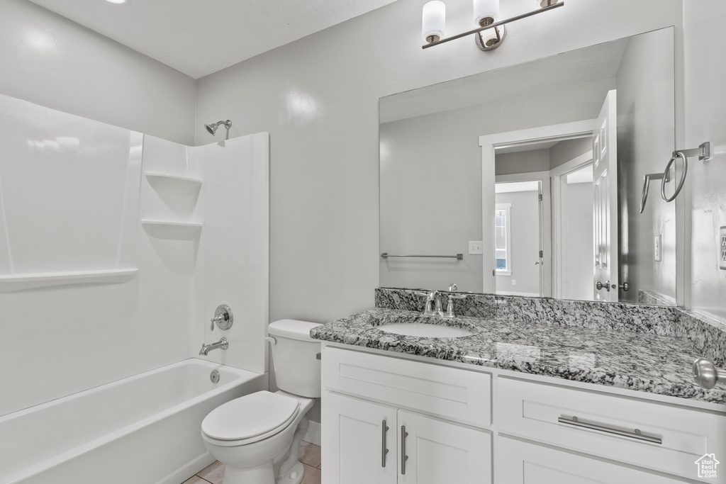 Bathroom with vanity, toilet, bathing tub / shower combination, and tile patterned flooring