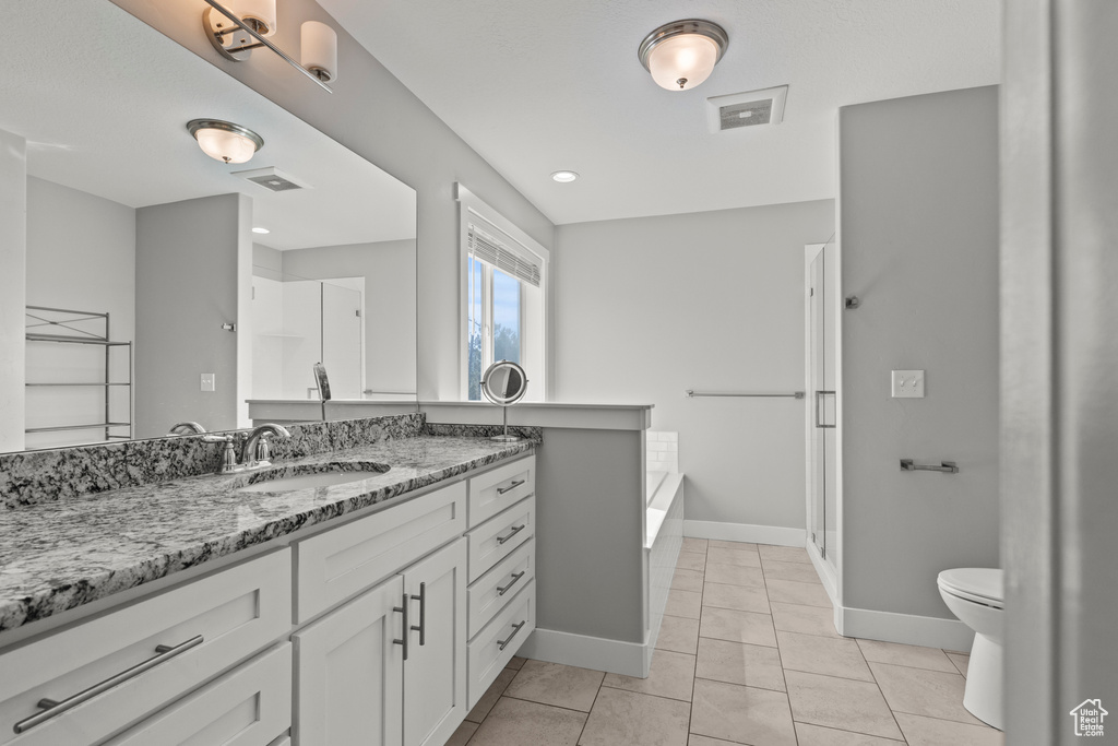 Bathroom with toilet, baseboards, vanity, and a bath