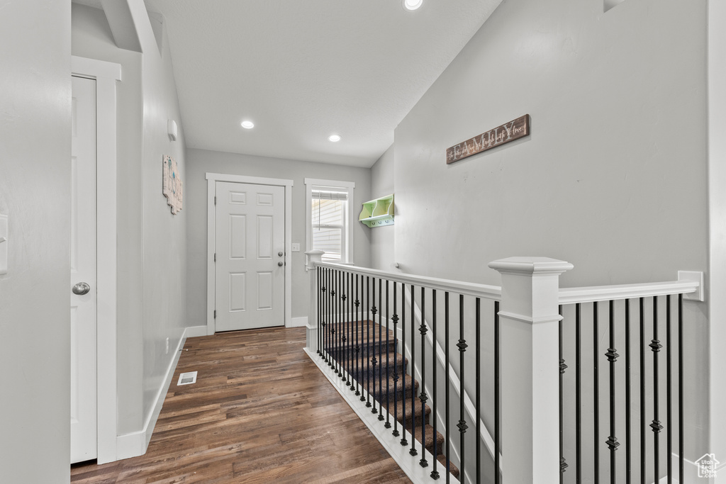 Corridor with wood finished floors, baseboards, recessed lighting, and an upstairs landing