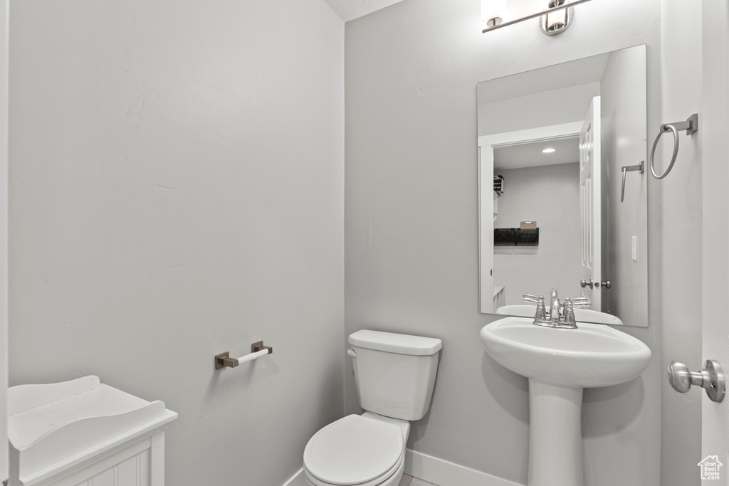 Half bathroom featuring toilet and baseboards