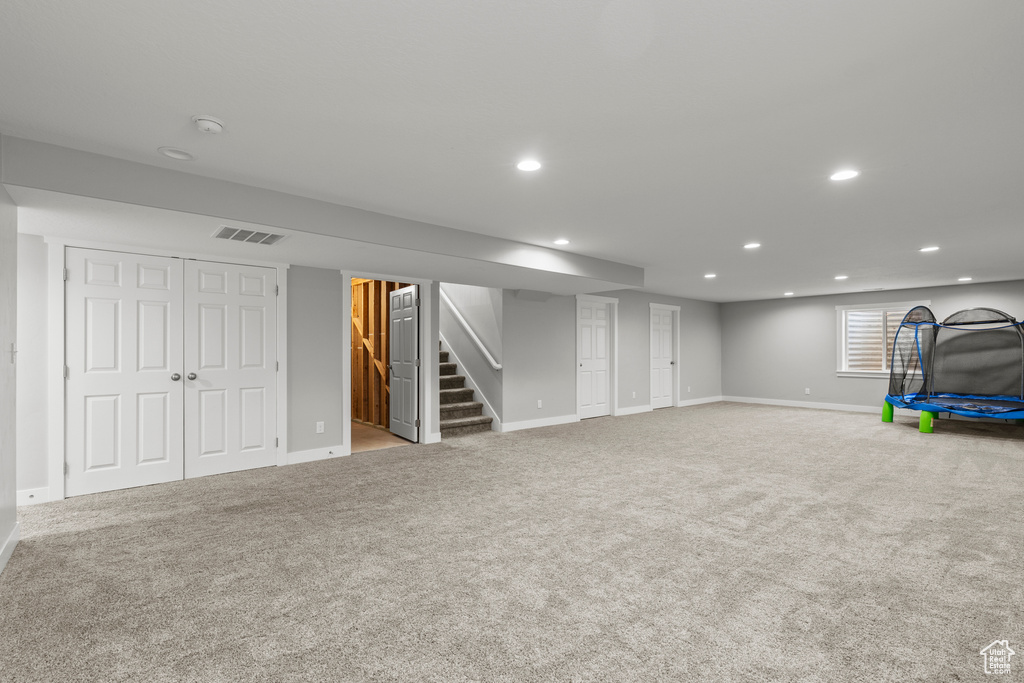 Basement with recessed lighting, baseboards, carpet flooring, and stairway