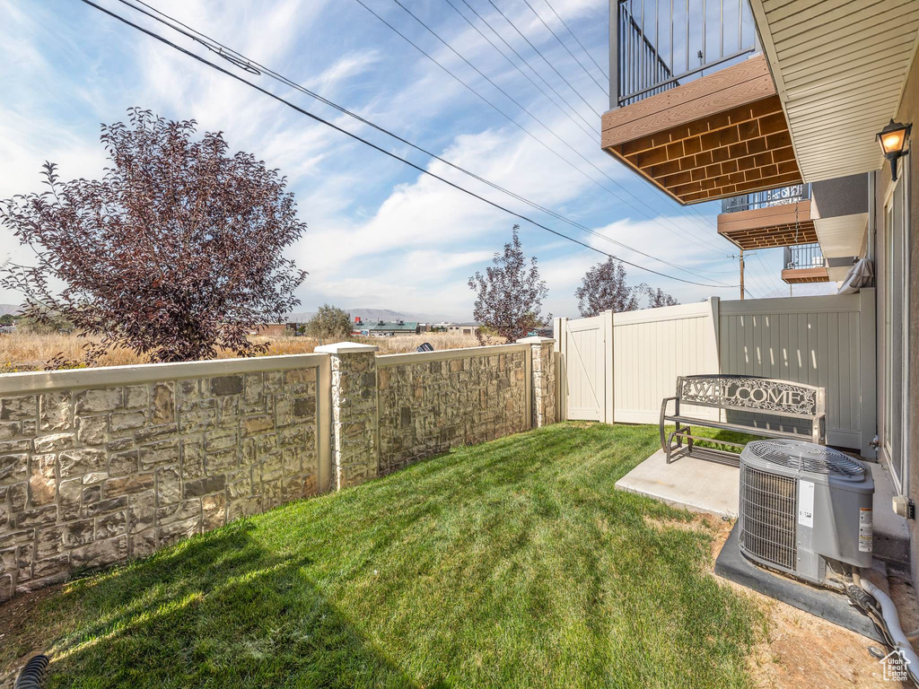 View of yard featuring a balcony, cooling unit, and a patio