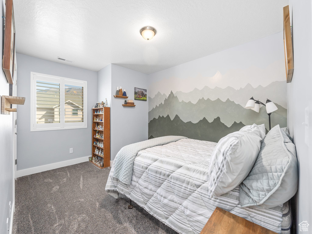 Carpeted bedroom with a textured ceiling