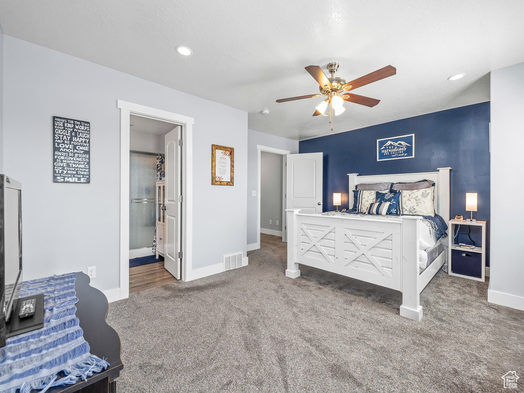 Carpeted bedroom featuring ceiling fan and ensuite bathroom