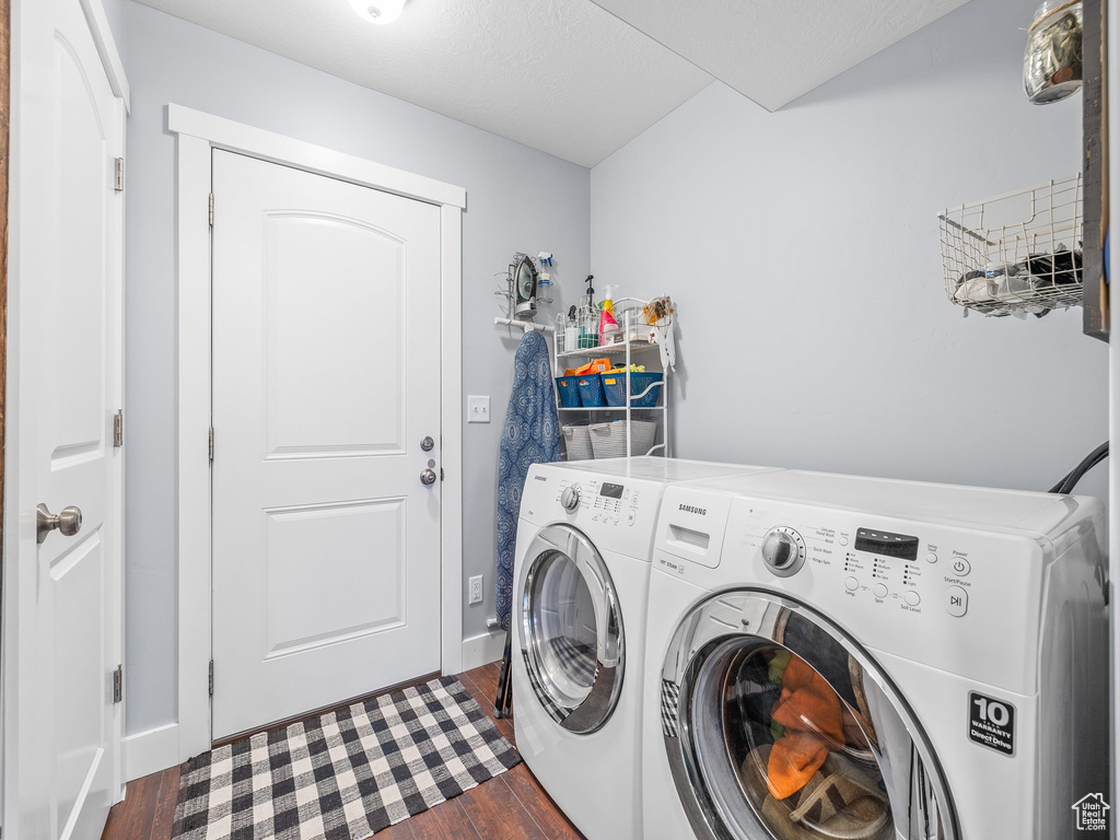 Laundry room with dark hardwood / wood-style floors and washer and dryer