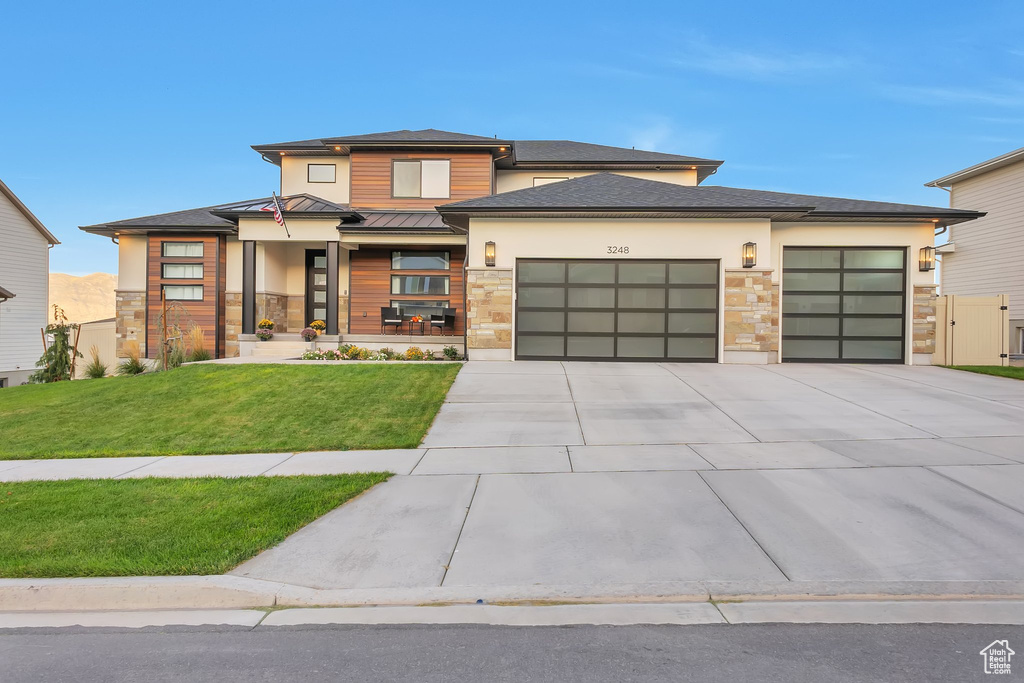 Prairie-style home featuring a garage and a front yard