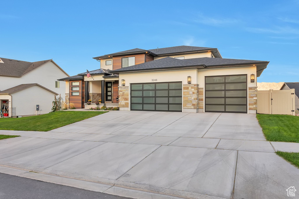 Prairie-style home featuring a garage and a front yard