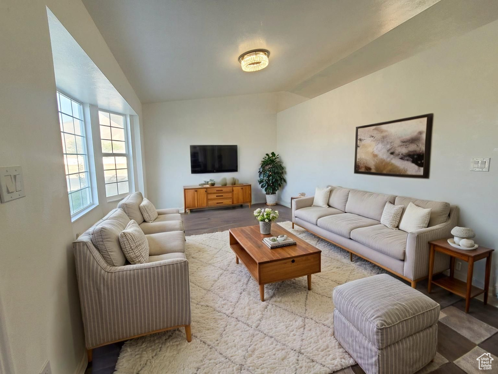 Living area featuring lofted ceiling and baseboards