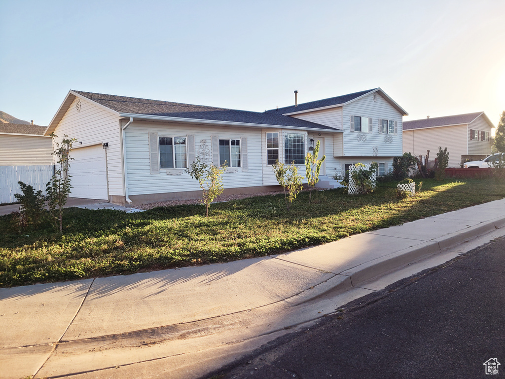 Split level home with a garage and a front lawn