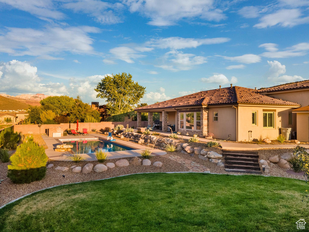 View of pool with a lawn and a patio