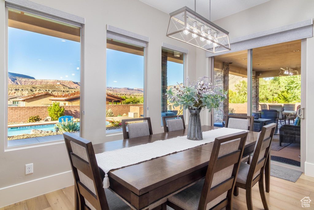 Dining area featuring a chandelier, light hardwood / wood-style floors, and a healthy amount of sunlight