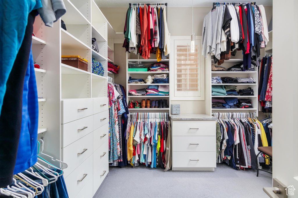 Walk in closet with light colored carpet