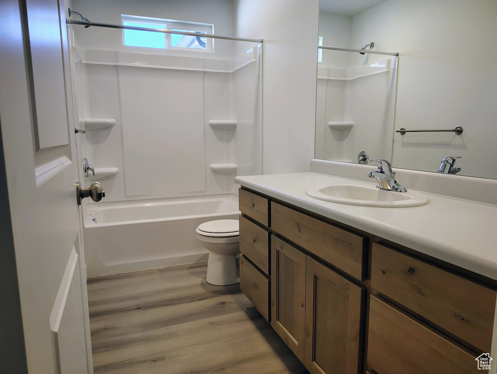 Full bathroom with  shower combination, vanity, hardwood / wood-style floors, and toilet