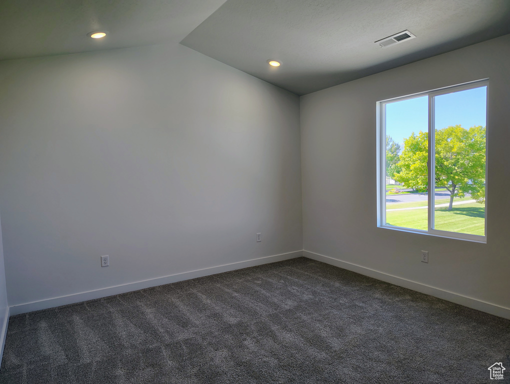 Carpeted spare room with lofted ceiling