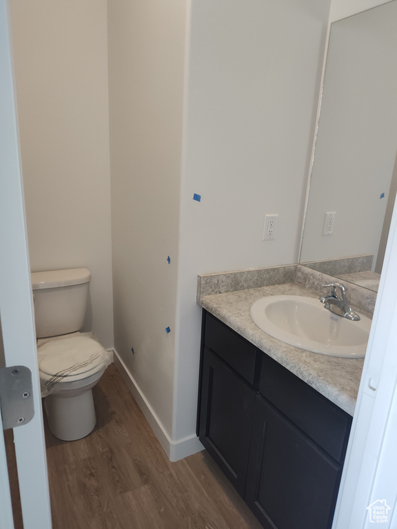 Bathroom with vanity, toilet, and hardwood / wood-style flooring