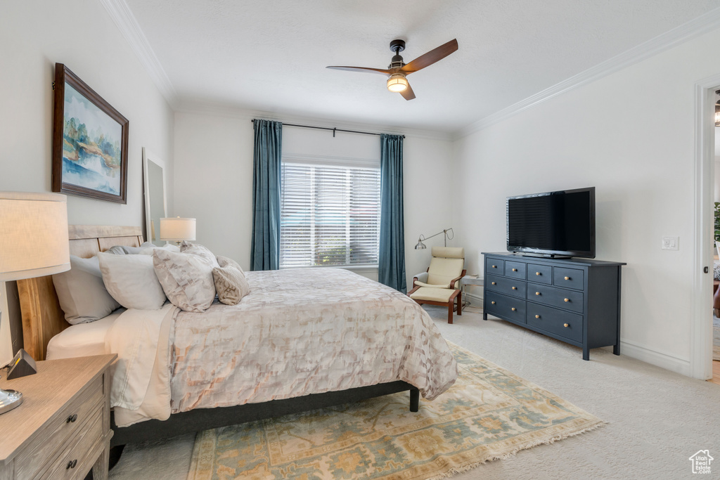 Bedroom featuring light carpet, ceiling fan, and crown molding