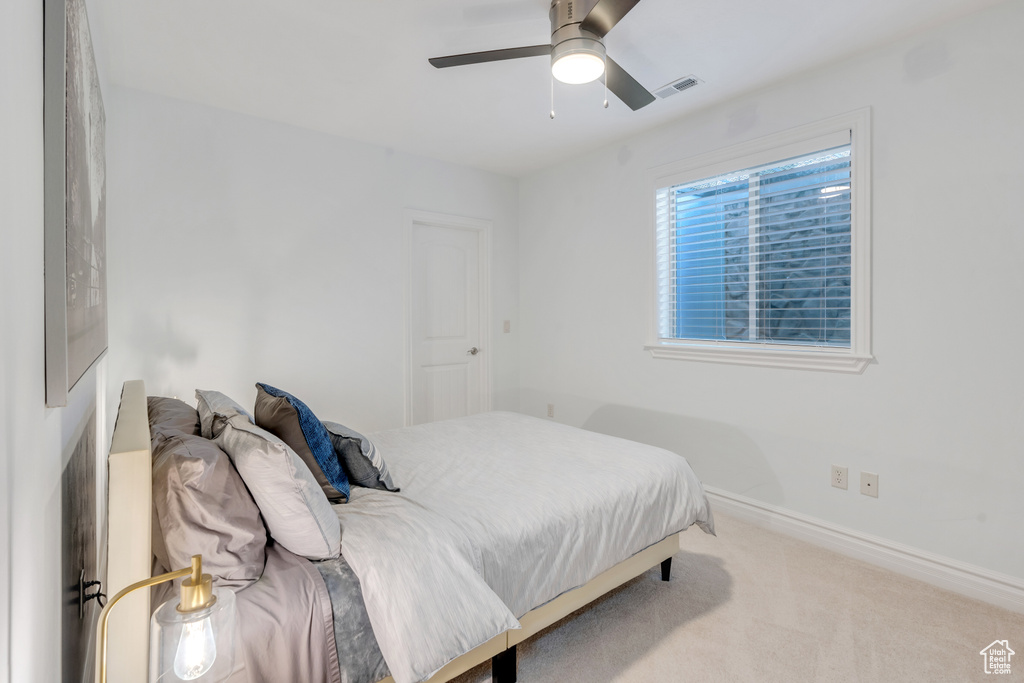 Carpeted bedroom featuring ceiling fan