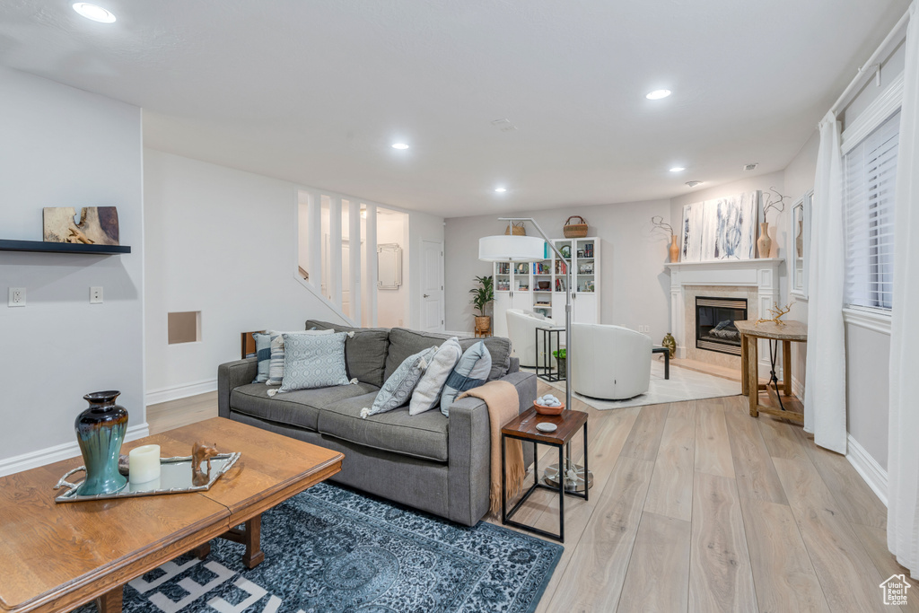 Living room with light hardwood / wood-style flooring and a high end fireplace