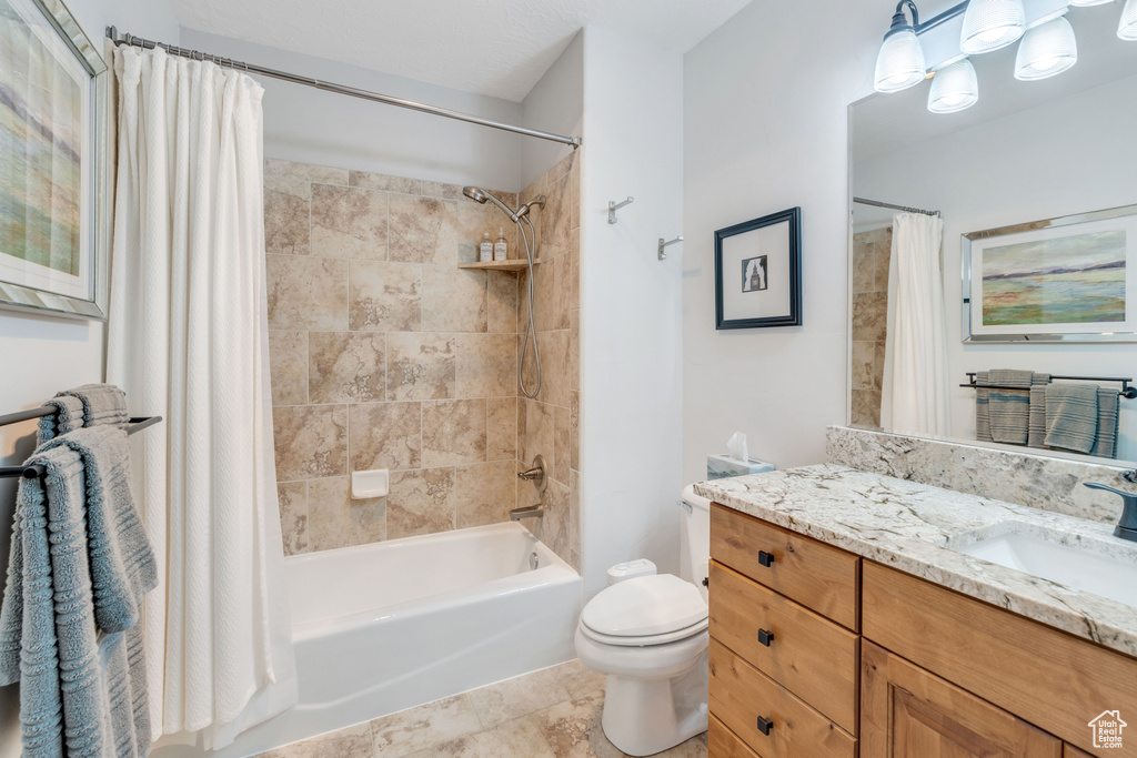 Full bathroom with shower / tub combo with curtain, vanity, toilet, and tile patterned floors