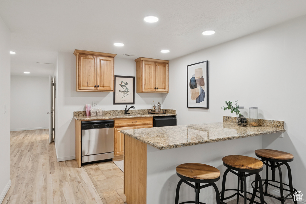 Kitchen featuring dishwasher, a breakfast bar area, a peninsula, recessed lighting, and black dishwasher