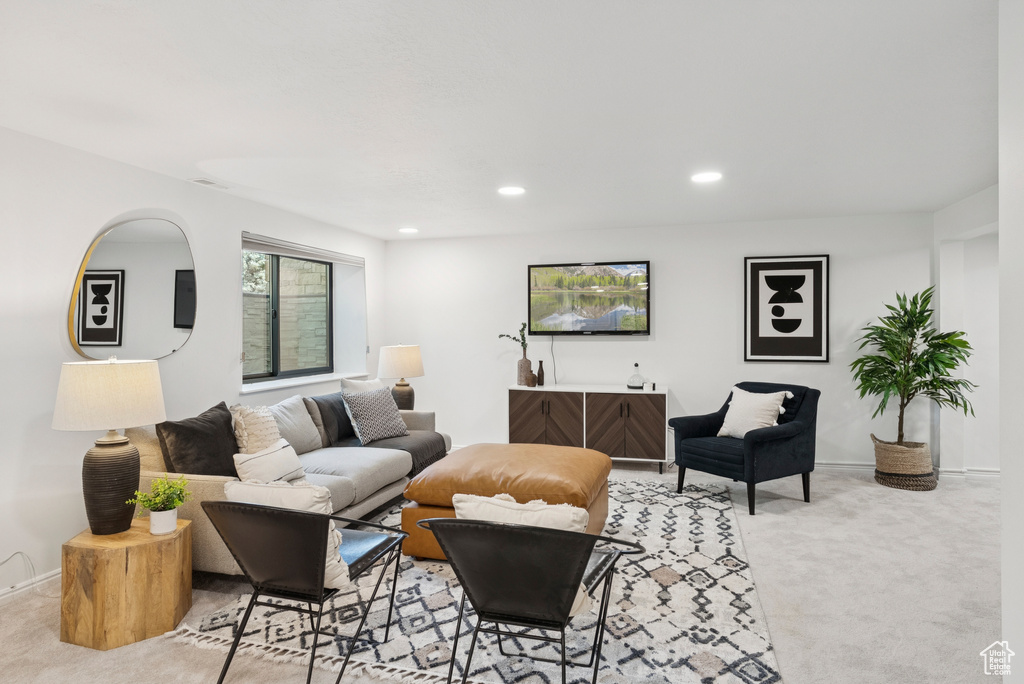 Living area with light carpet and recessed lighting