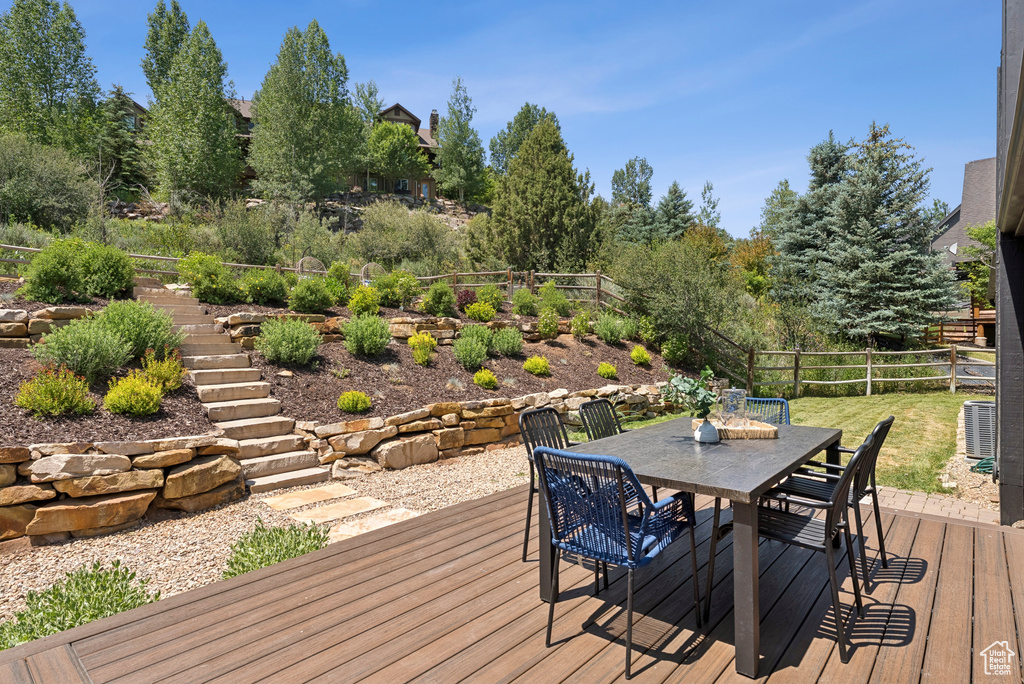 Wooden deck featuring outdoor dining space and stairs