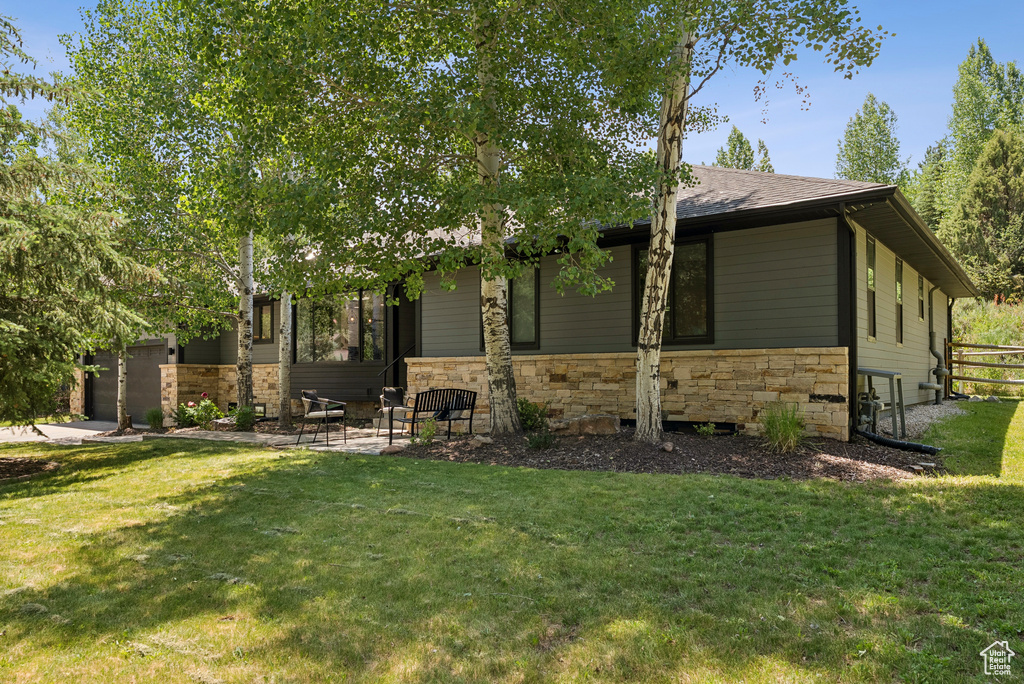 View of front of property with stone siding and a front lawn