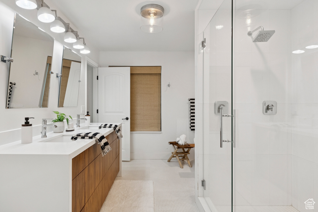 Full bathroom with a shower stall, double vanity, and tile patterned floors