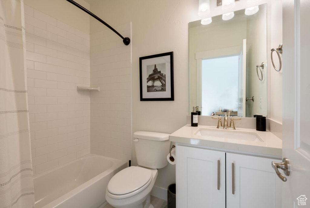 Full bathroom featuring vanity, toilet, and shower / bath combo with shower curtain