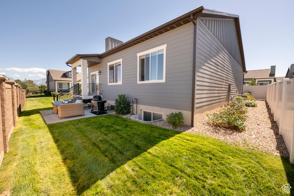 View of side of property with an outdoor hangout area, a yard, and a patio area