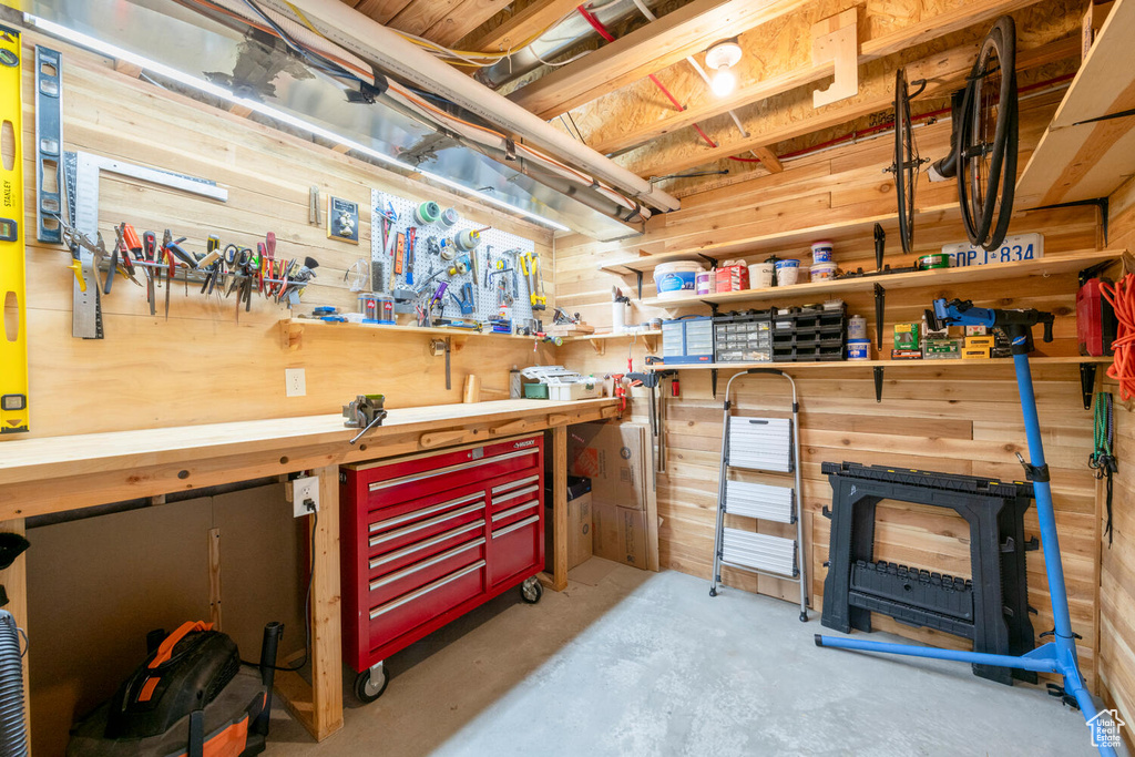 Basement with wooden walls and a workshop area