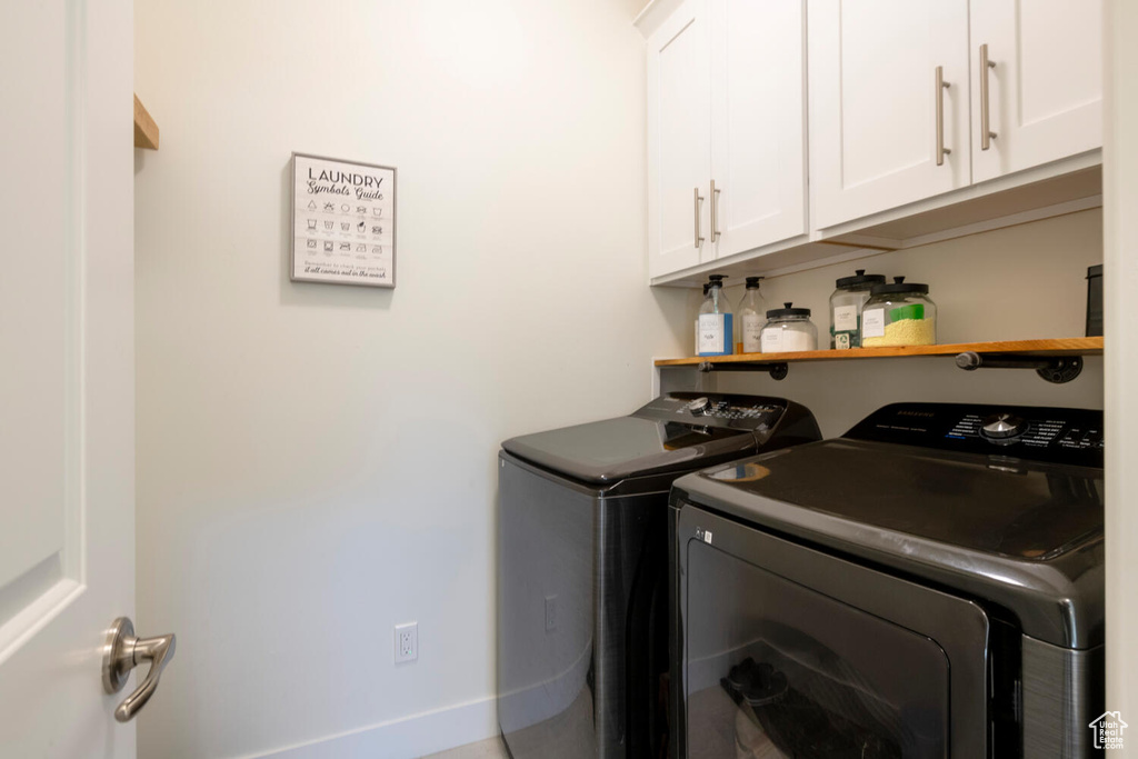 Laundry area featuring cabinets and separate washer and dryer