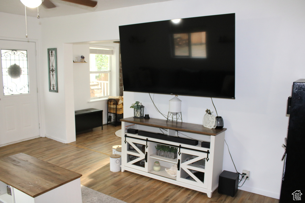 Living room with ceiling fan and hardwood / wood-style floors