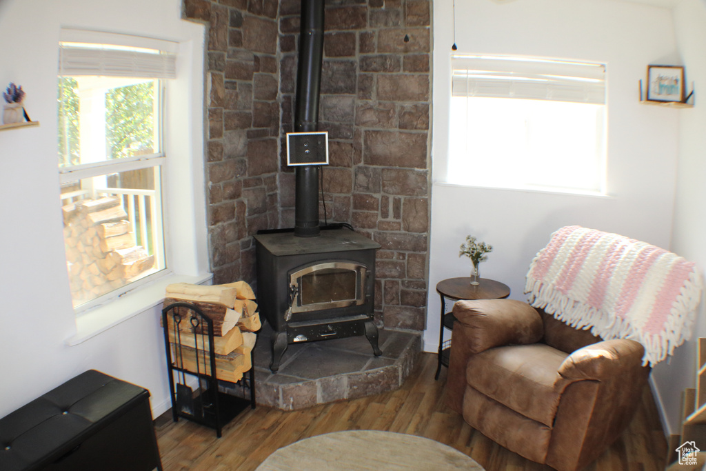 Sitting room featuring hardwood / wood-style floors and a wood stove