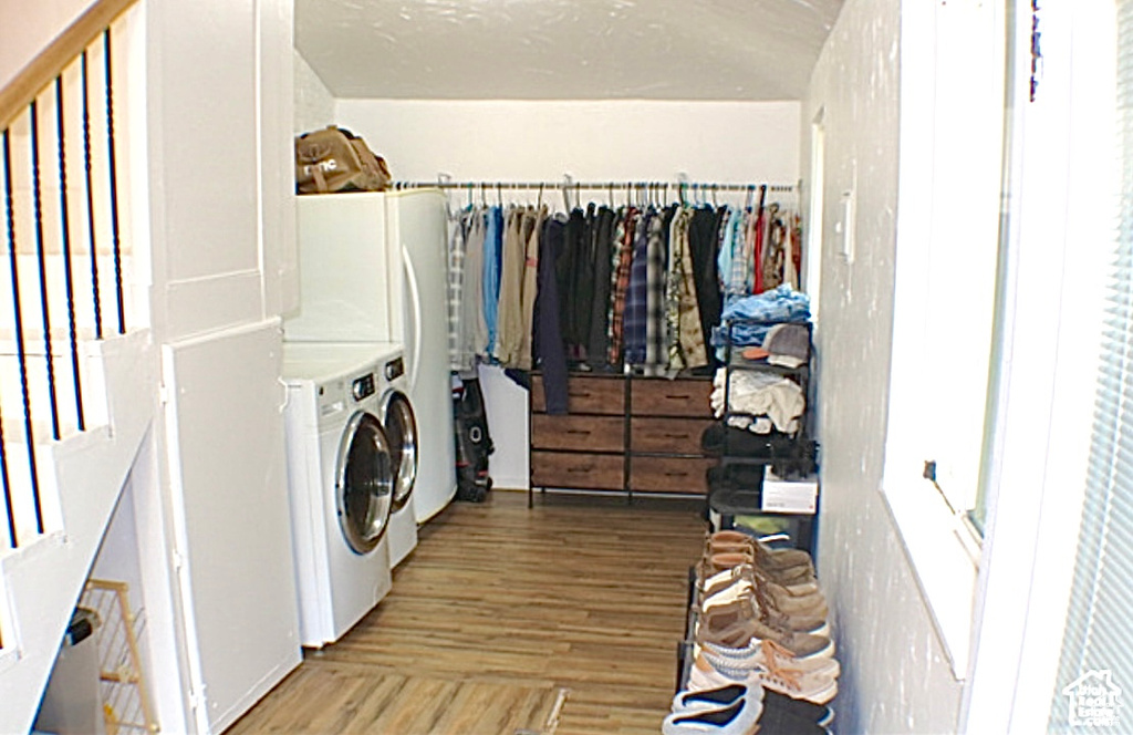 Laundry area with wood-type flooring and washing machine and clothes dryer