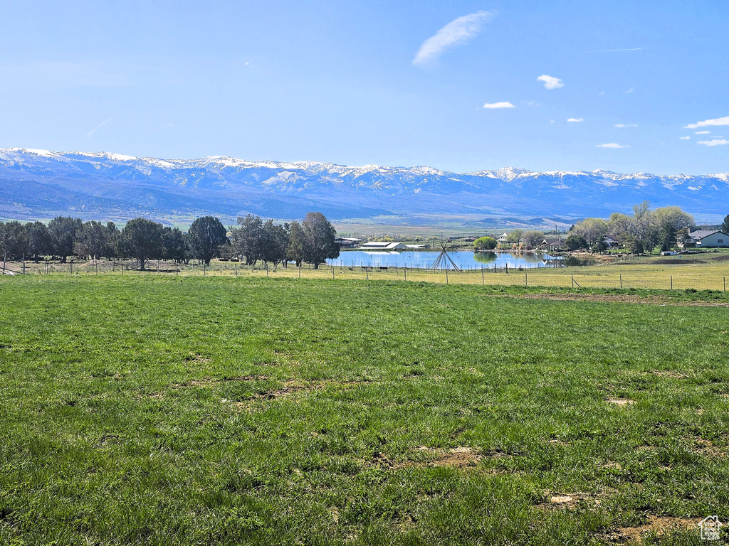View of mountain backdrop with a nearby body of water and rural landscape