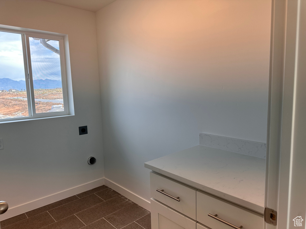 Laundry room featuring a healthy amount of sunlight, a mountain view, and hookup for an electric dryer