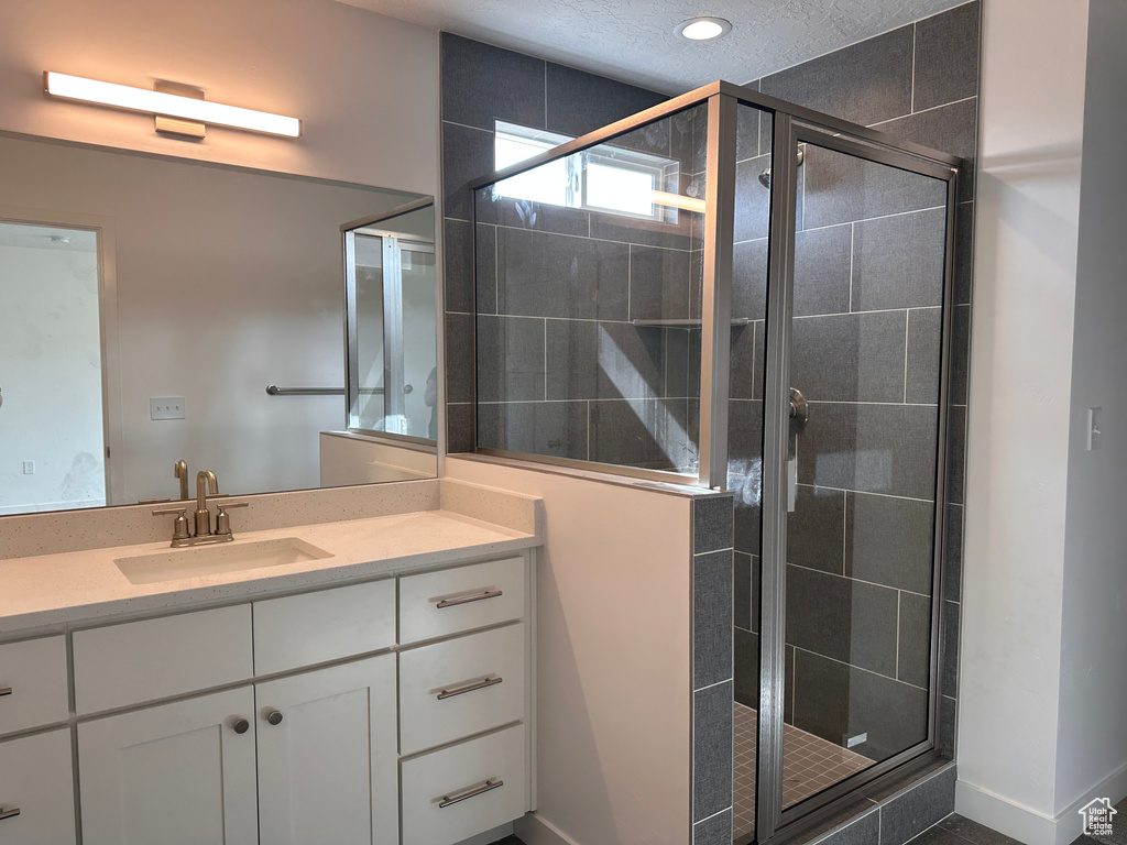 Bathroom with vanity and a shower with shower door