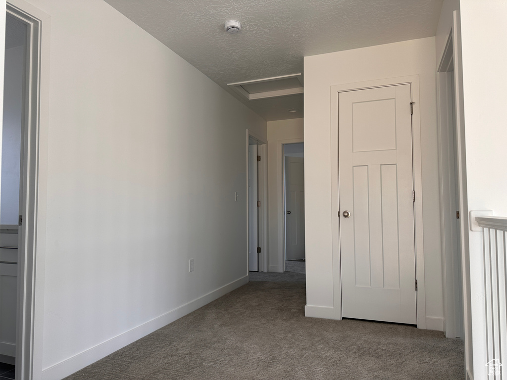 Unfurnished bedroom with light carpet and a textured ceiling